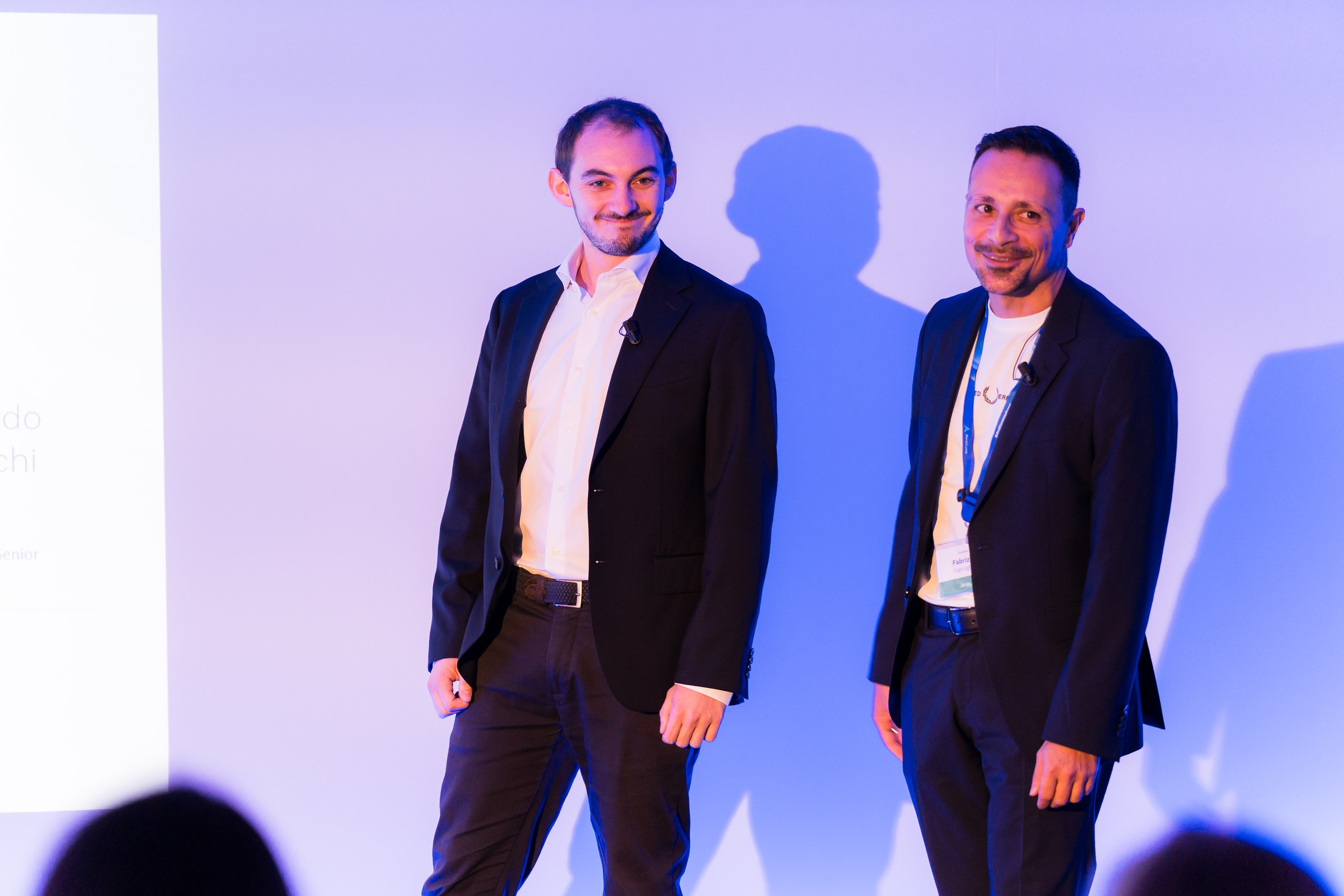 JAKALA’s Head of HR Innovation & Digital Transformation Fabrizio Caprioglio and HR Innovation Senior Specialist Leonardo Cenacchistanding on stage during a conference presentation.
